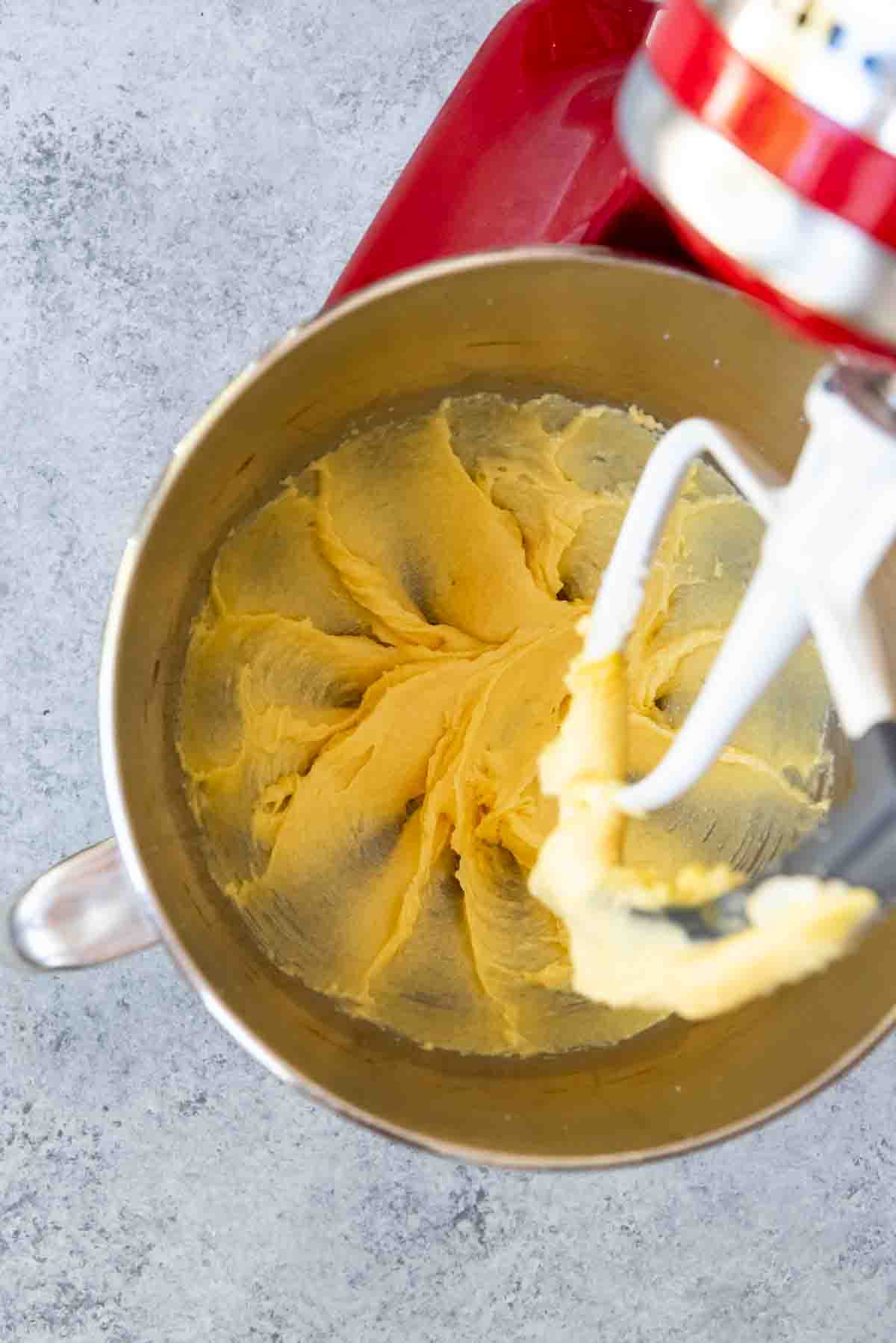 Creaming butter and sour cream in a bowl.