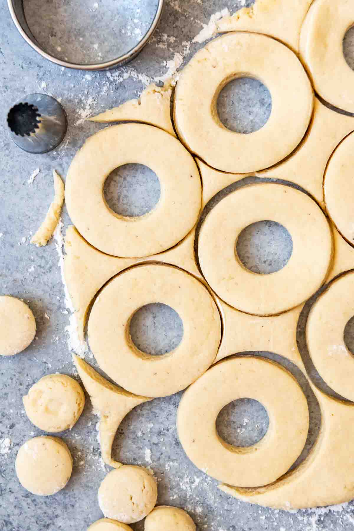 Doughnut dough being cut out into circles.