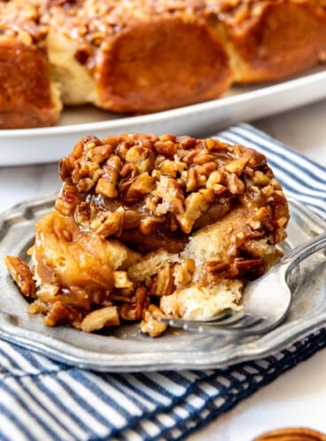 An image of a caramel pecan roll on a plate.