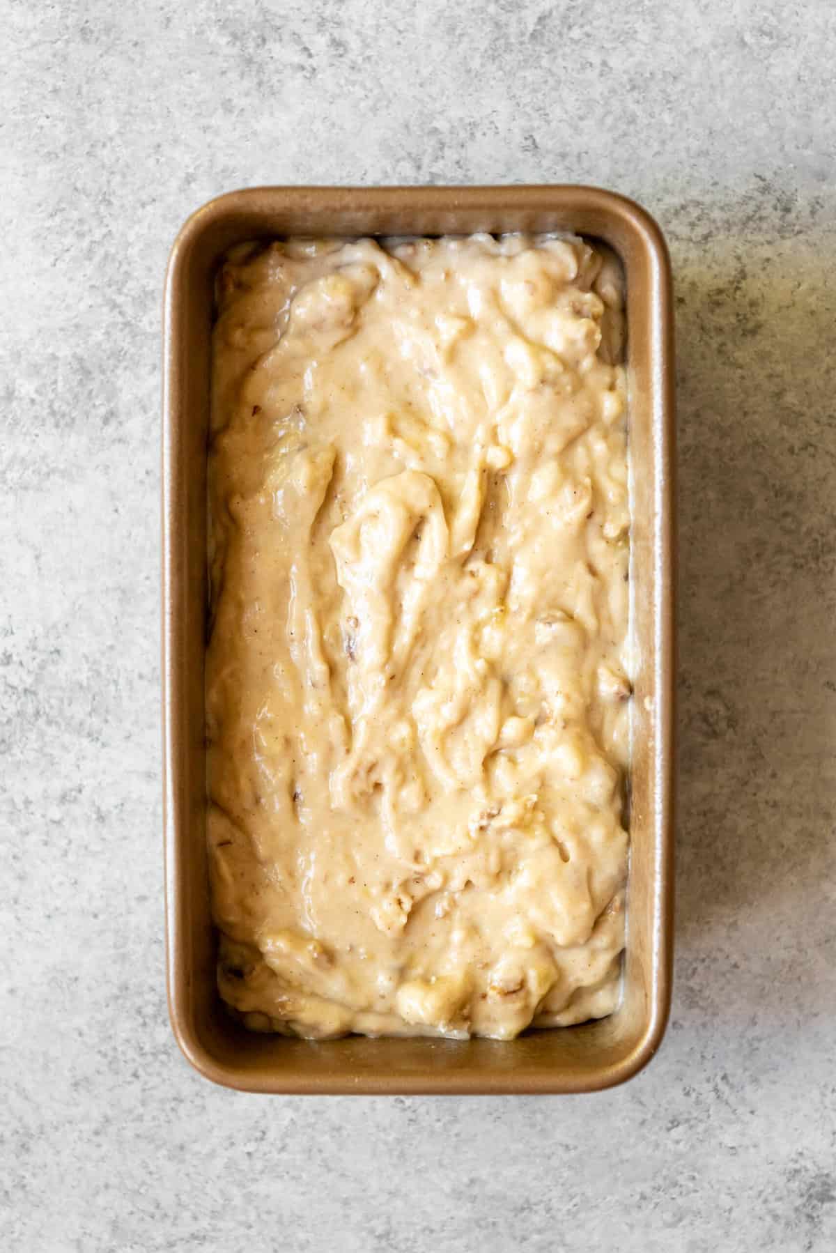 A loaf pan with batter for banana bread.