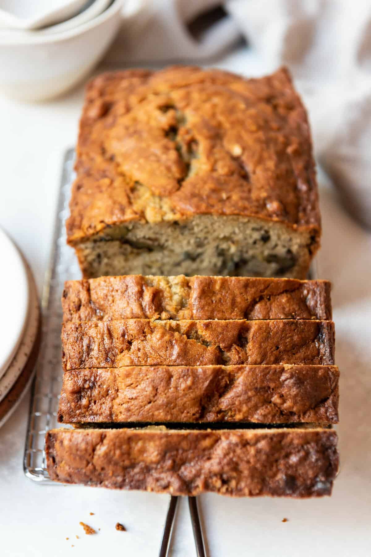 An image of a loaf of fresh, moist banana bread on a cutting board.