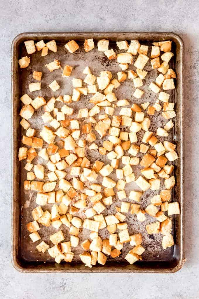 An image of cubed hamburger buns on a baking sheet to be toasted and made into croutons.