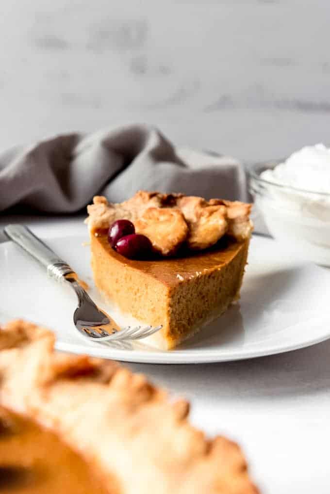 An image of a slice of pumpkin pie on a plate with a fork.