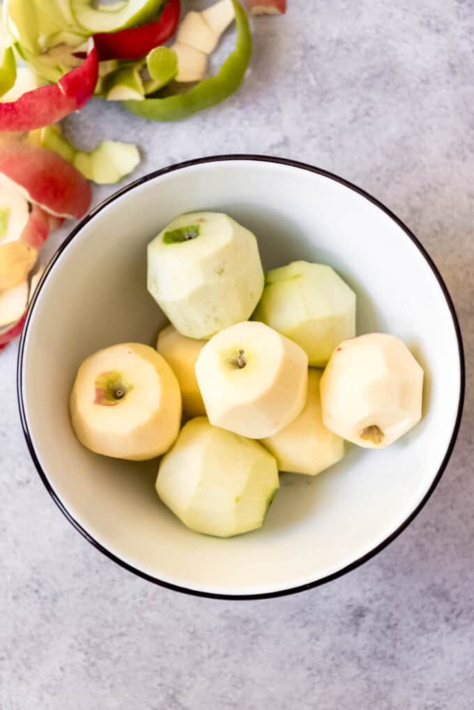 Peeled whole apples in a bowl.