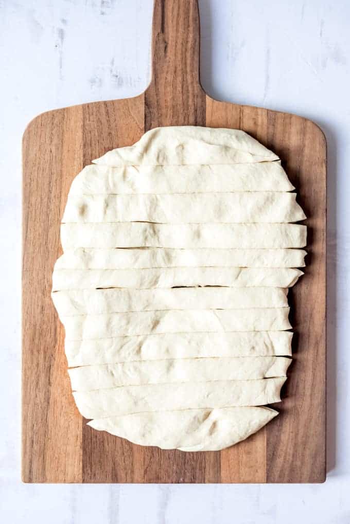 An image of dough that has been cut into strips for making breadsticks.