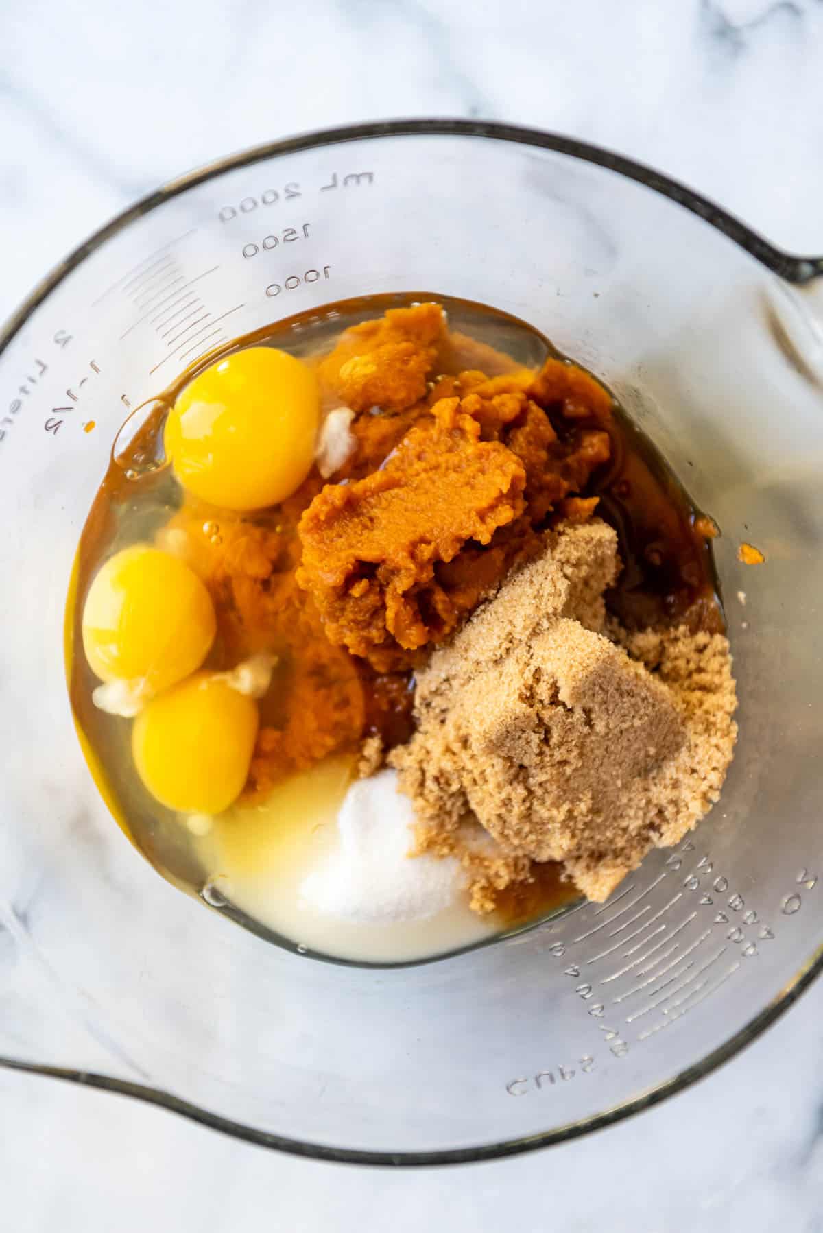 Combining eggs, sugar, and pumpkin puree in a large bowl.