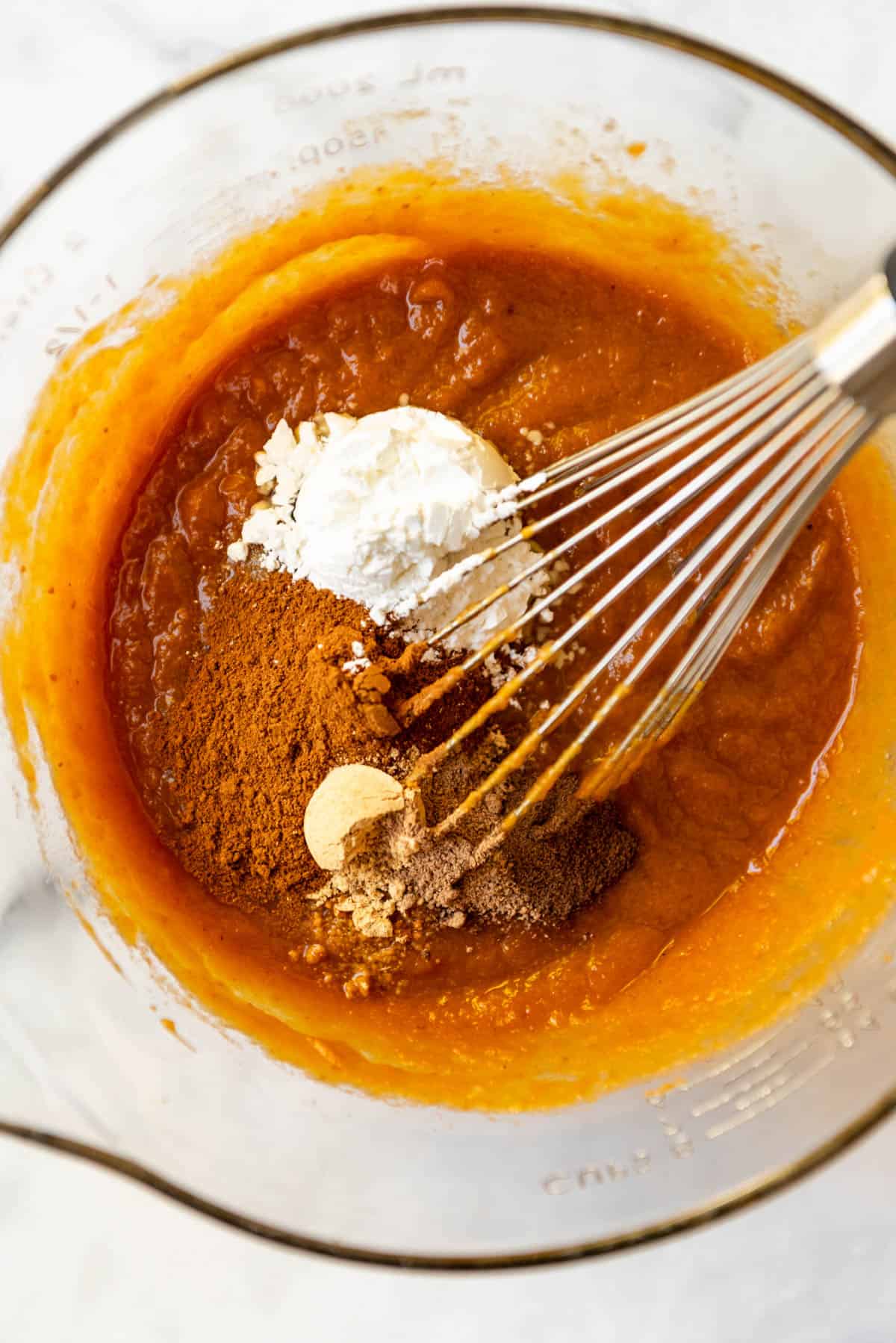 Whisking pumpkin pie spices into pumpkin pie filling.