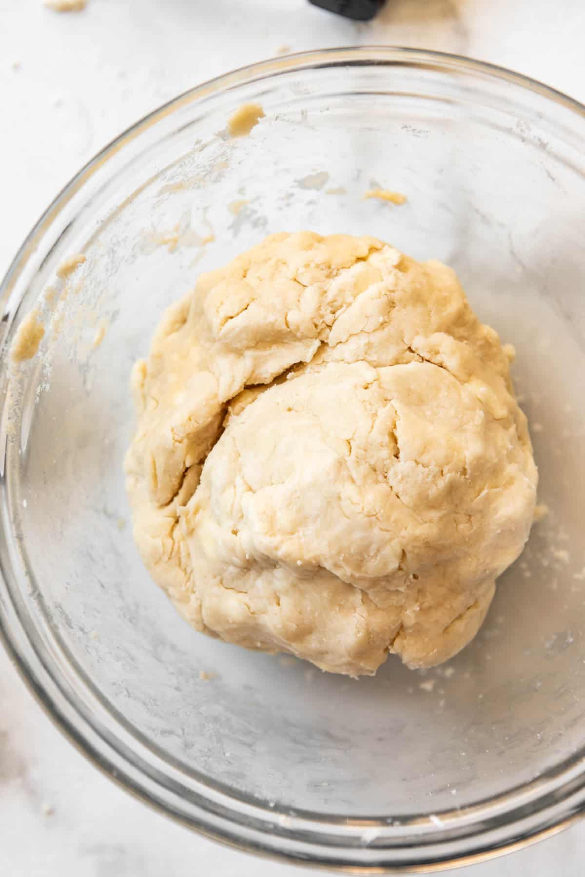 Pie crust dough in a glass bowl.