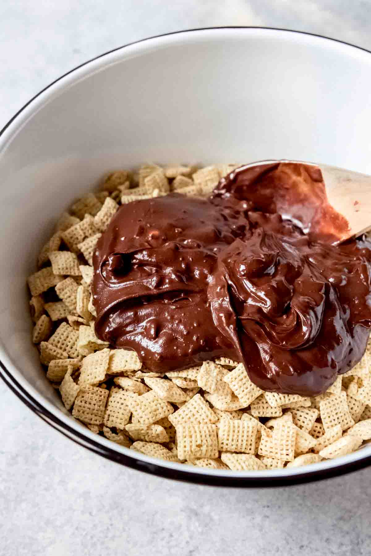 An image of melted chocolate and peanut butter poured over rice Chex cereal.