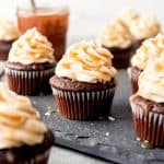 An image of chocolate cupcakes with salted caramel frosting on top.