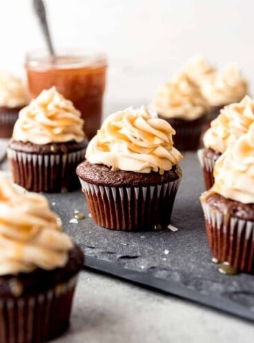 An image of chocolate cupcakes with salted caramel frosting on top.