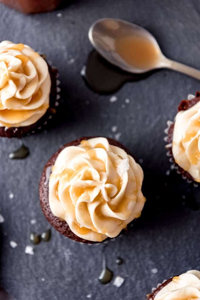 An image of swirls of salted caramel frosting piped onto chocolate cupcakes.