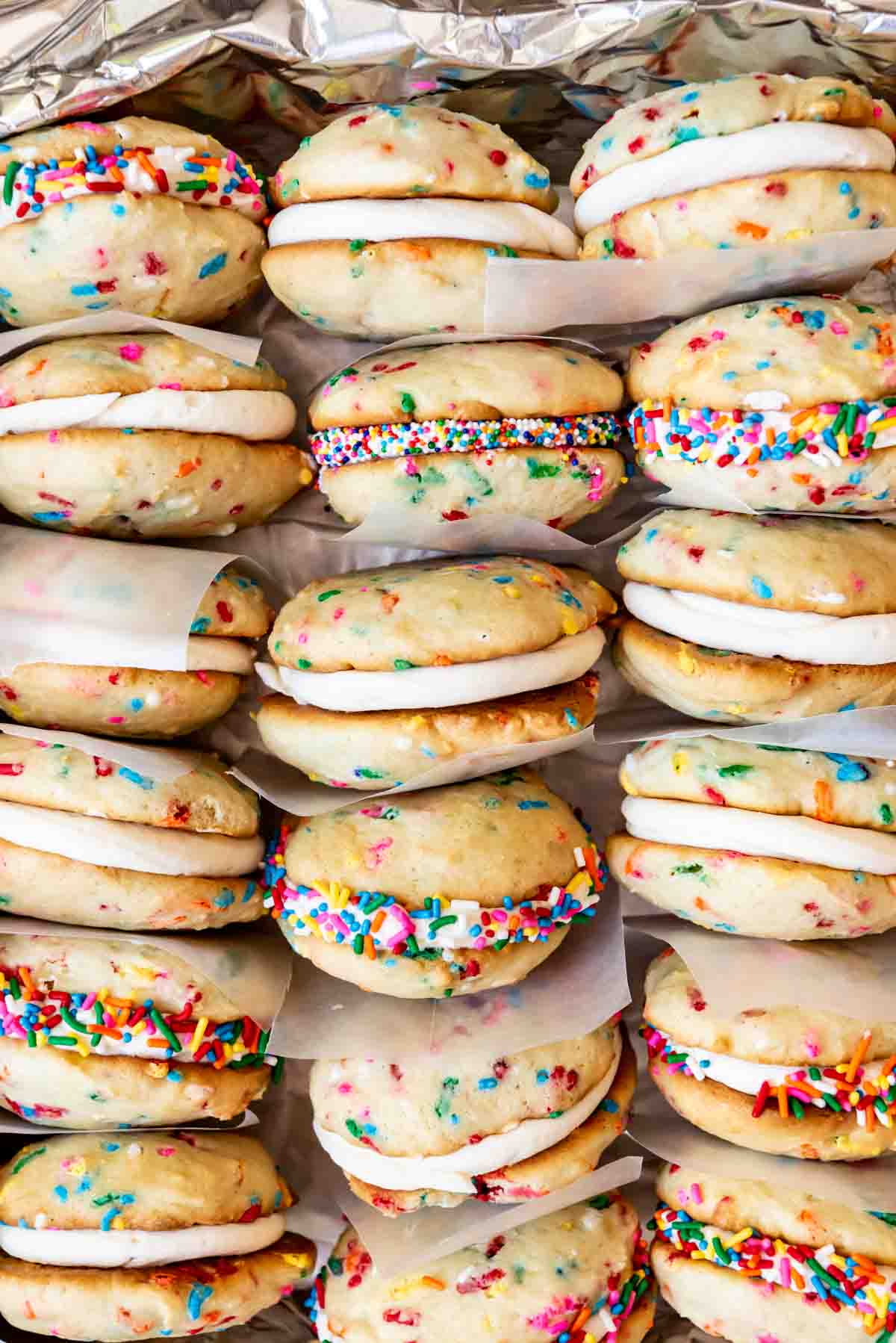 An image of sprinkle whoopie pies stacked with squares of wax paper between them.