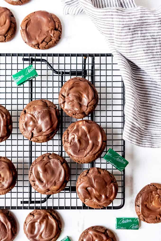An image of chocolate Andes mint cookies on a wire cooling rack.