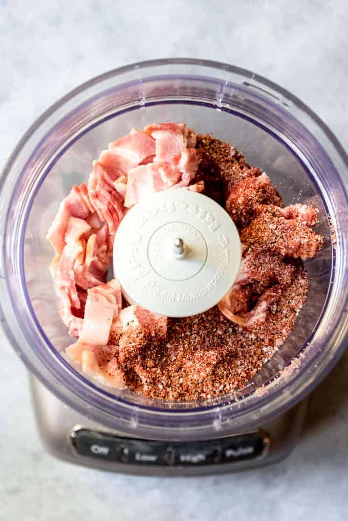 An image of bacon and spices in a food processor.