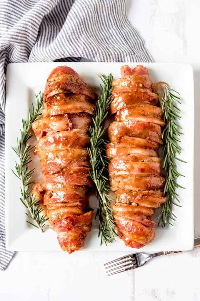 An image of two pork tenderloins wrapped in bacon.
