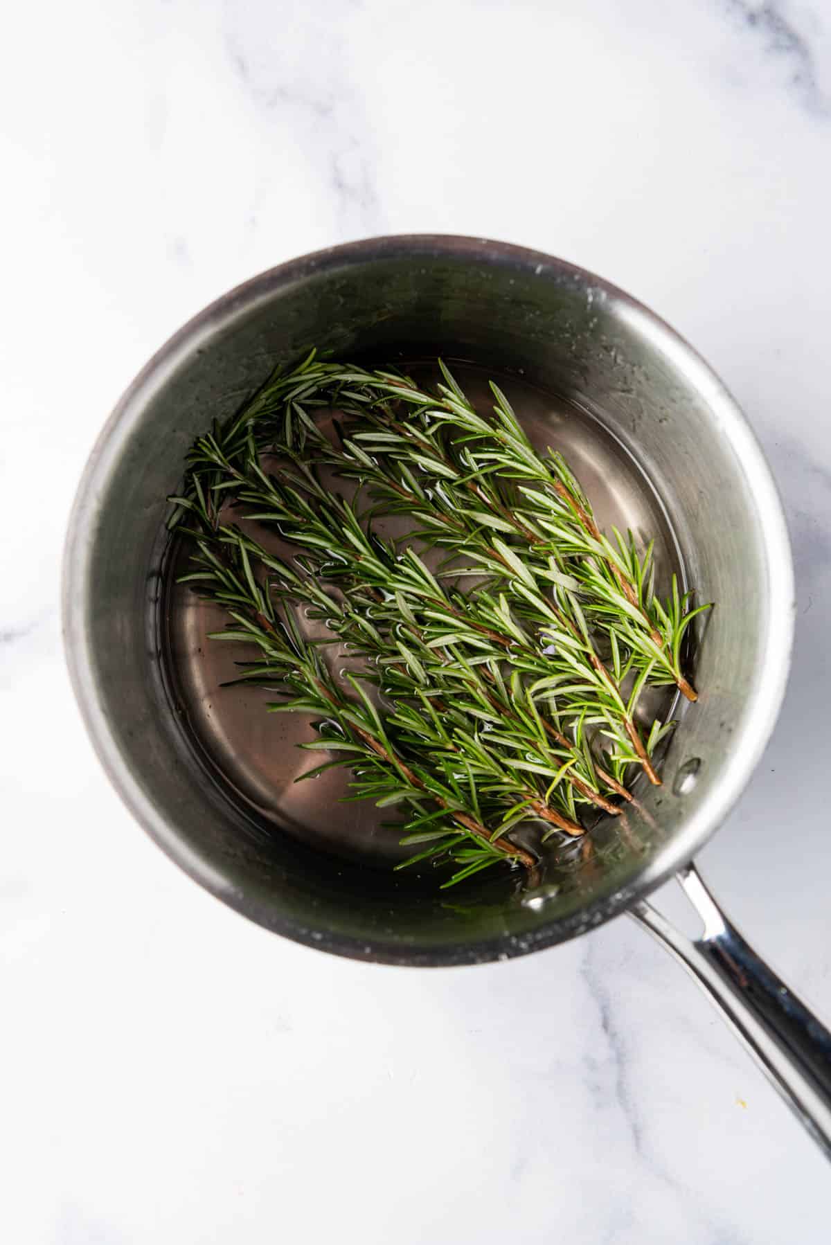 Fresh rosemary sprigs in a sugar syrup.