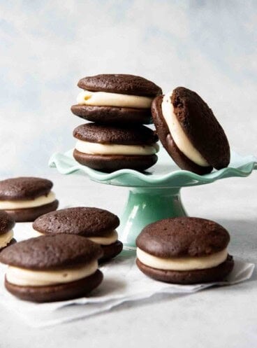 An image of chocolate salted caramel whoopie pies stacked on a cake stand.