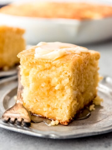 An image of a piece of moist sweet cornbread topped with honey and butter.
