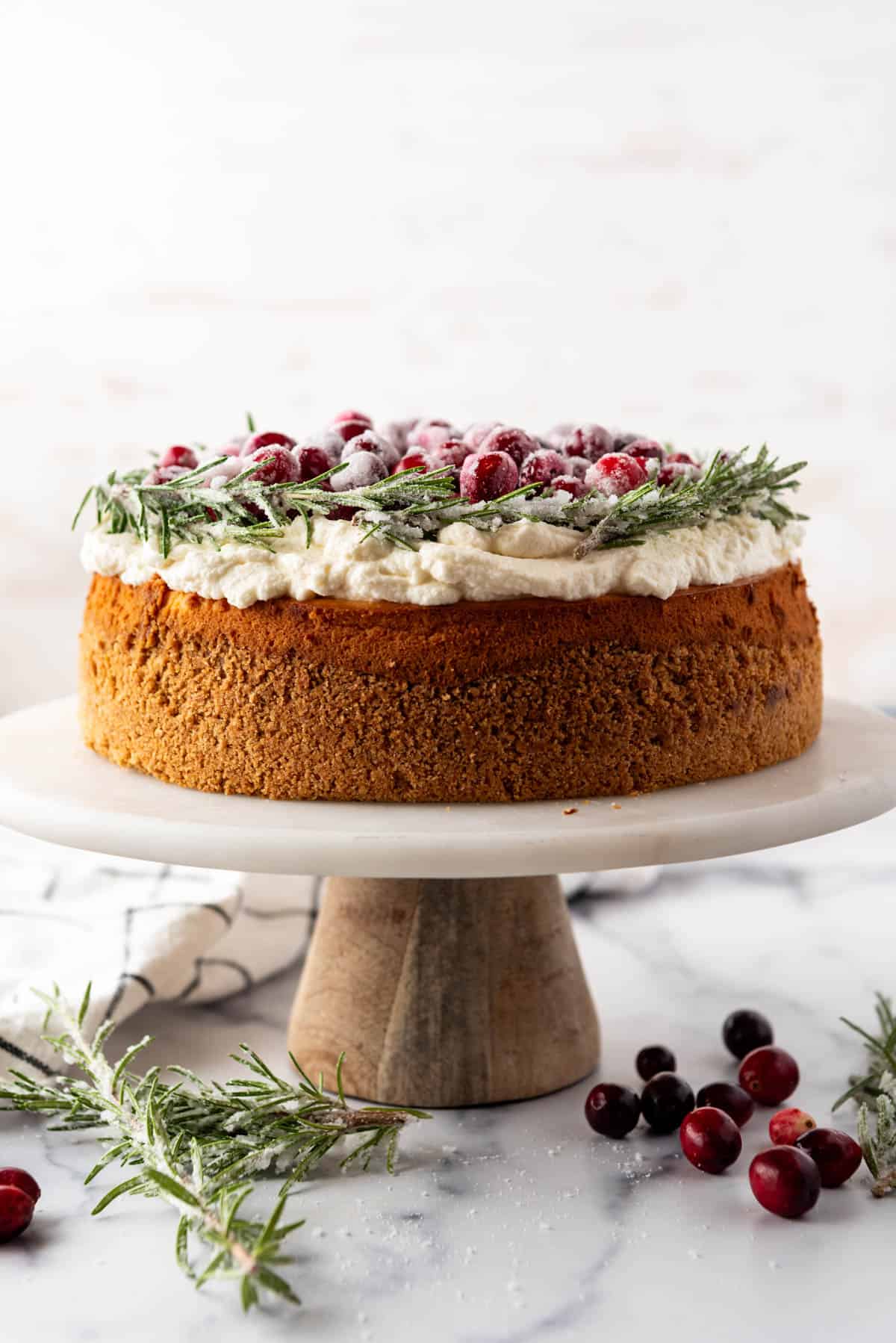 An image of an entire cranberry cheesecake on a cake stand.