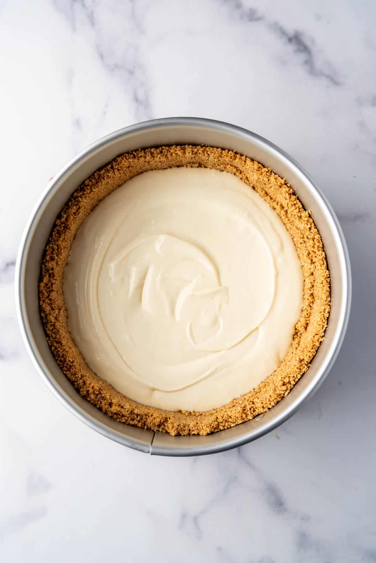 Cheesecake filling is added to the graham cracker crust