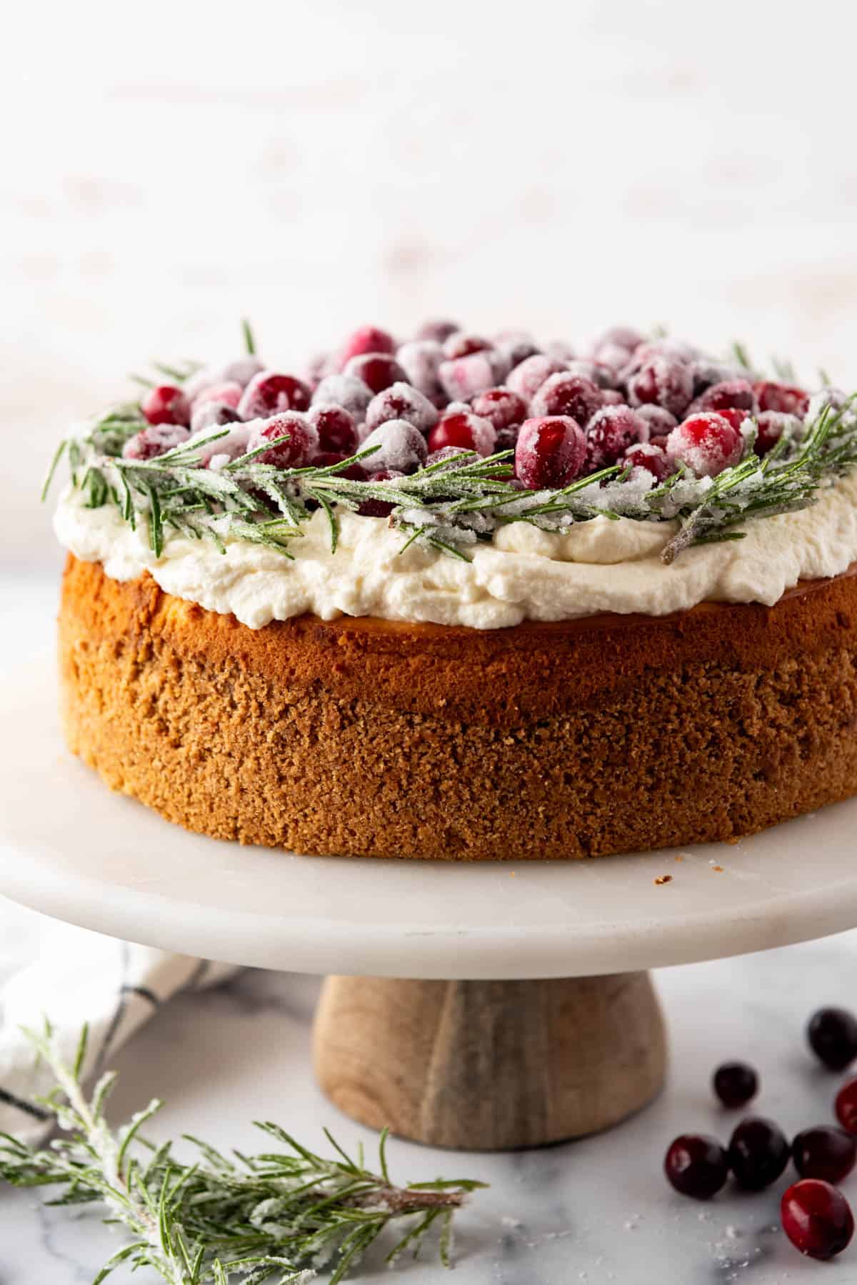 A festive Cranberry Christmas Cheesecake on a cake stand.