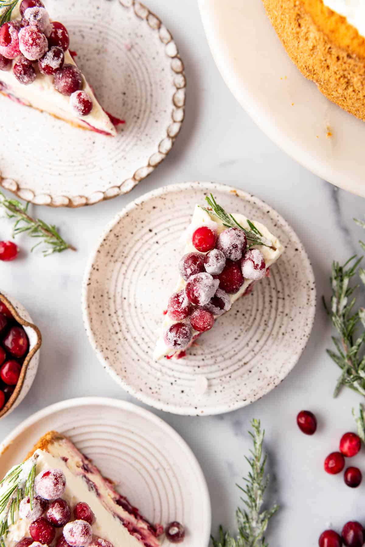 An overhead image of slices of cranberry cheesecake on plates.