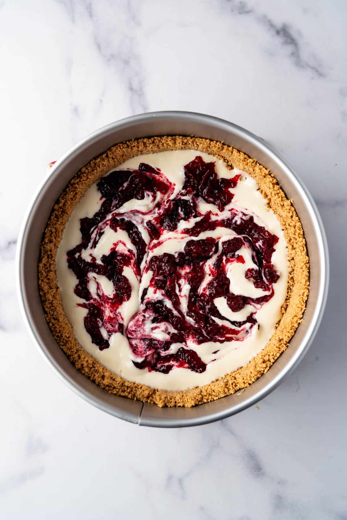 Swirling cranberry sauce into cheesecake batter.