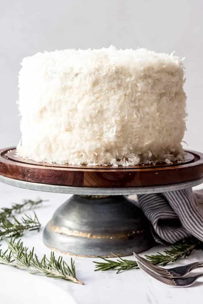 An image of a coconut cake on a cake stand.
