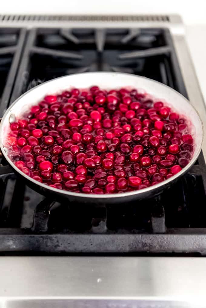 An image of fresh whole cranberries in a pan on the stove.