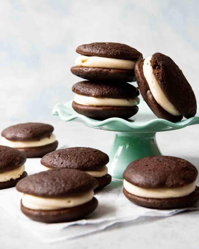 An image of chocolate salted caramel whoopie pies stacked on a cake stand.