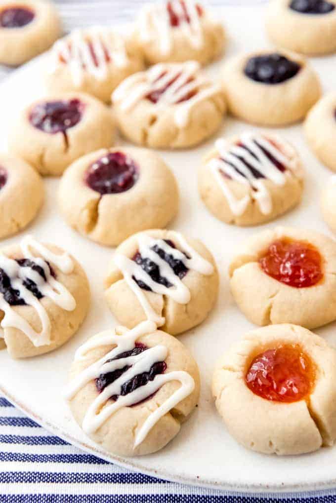 An image of shortbread thumbprint cookies filled with jam and drizzled with glaze.