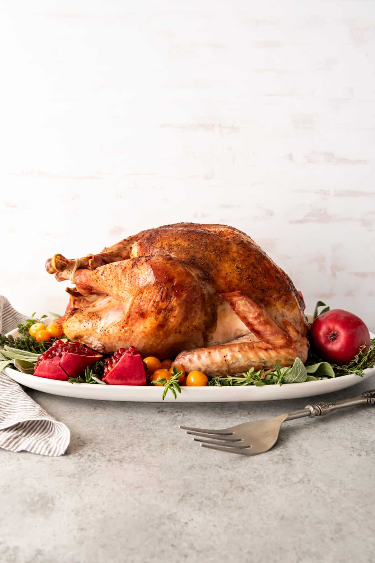 An image of a whole bacon roasted turkey on a serving plate.