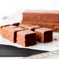 An image of creamy chocolate fudge cut into squares for serving.