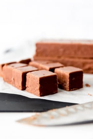 An image of creamy chocolate fudge cut into squares for serving.