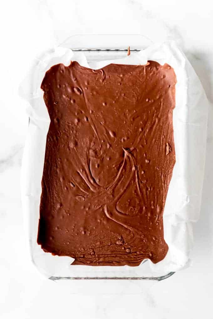 An image of chocolate fudge setting up in a 9x13-inch pan.