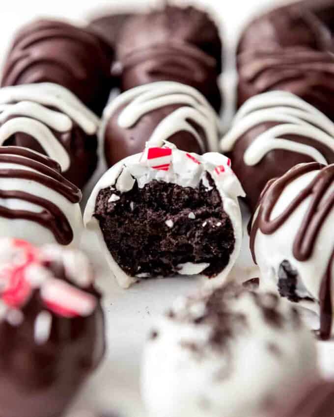 An image of a peppermint Oreo ball truffle with a bite taken out of it.