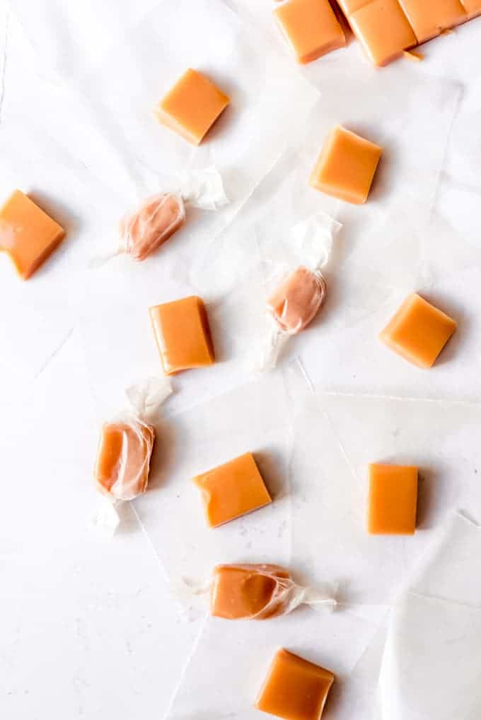An image of soft caramels that are being wrapped in waxed paper.