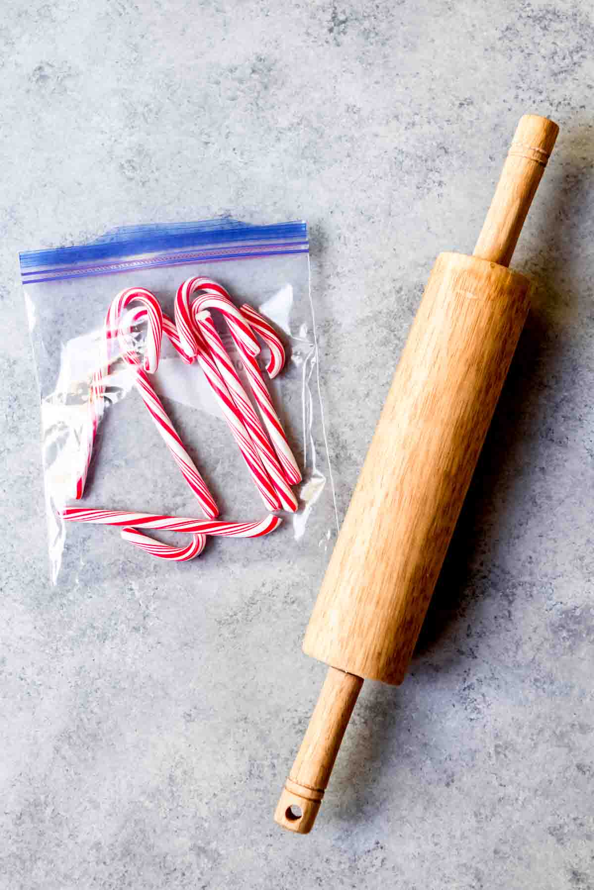 An image of candy canes in a ziploc bag with a rolling pin to crush them.