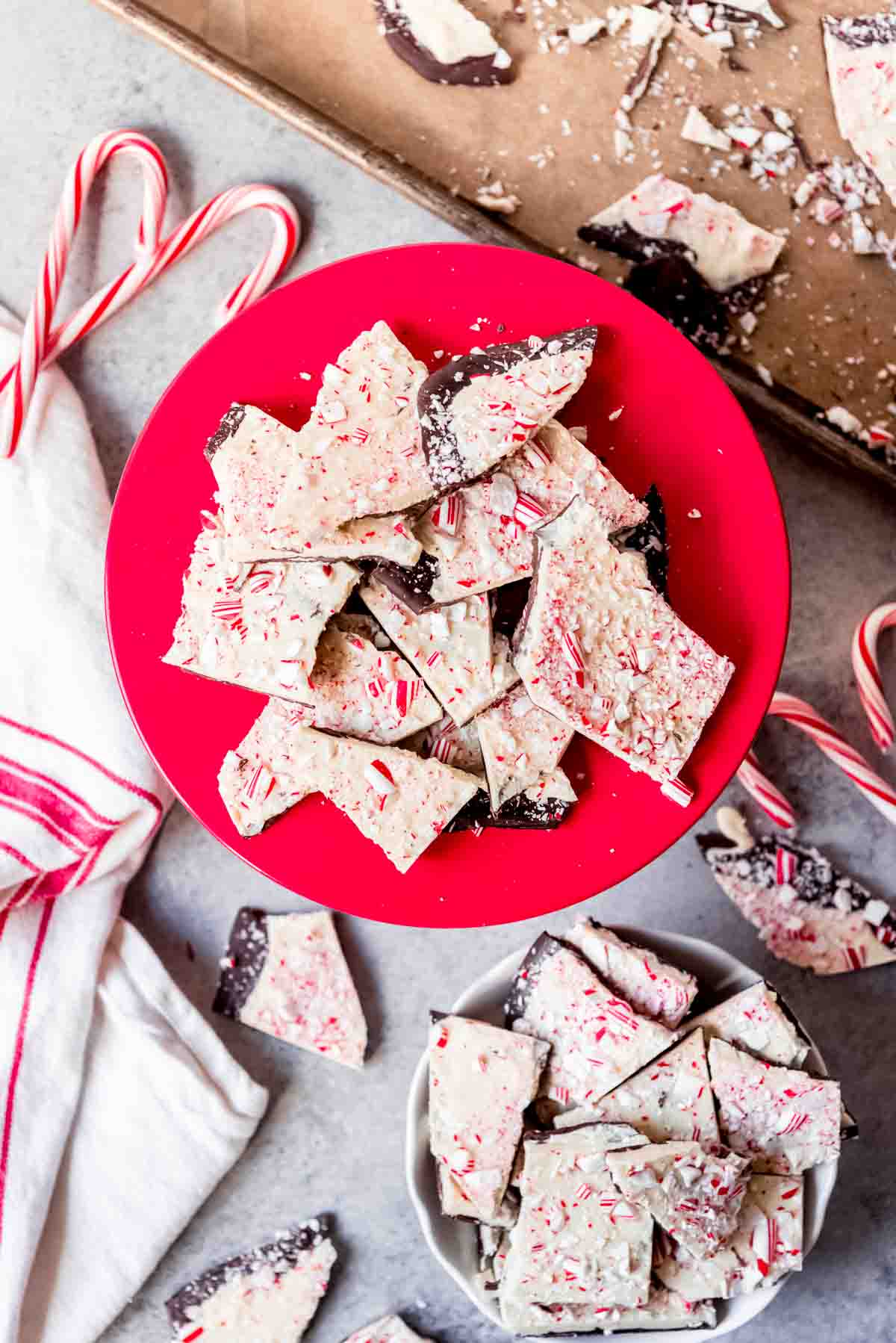 An image of candy cane peppermint bark on a red cake stand.