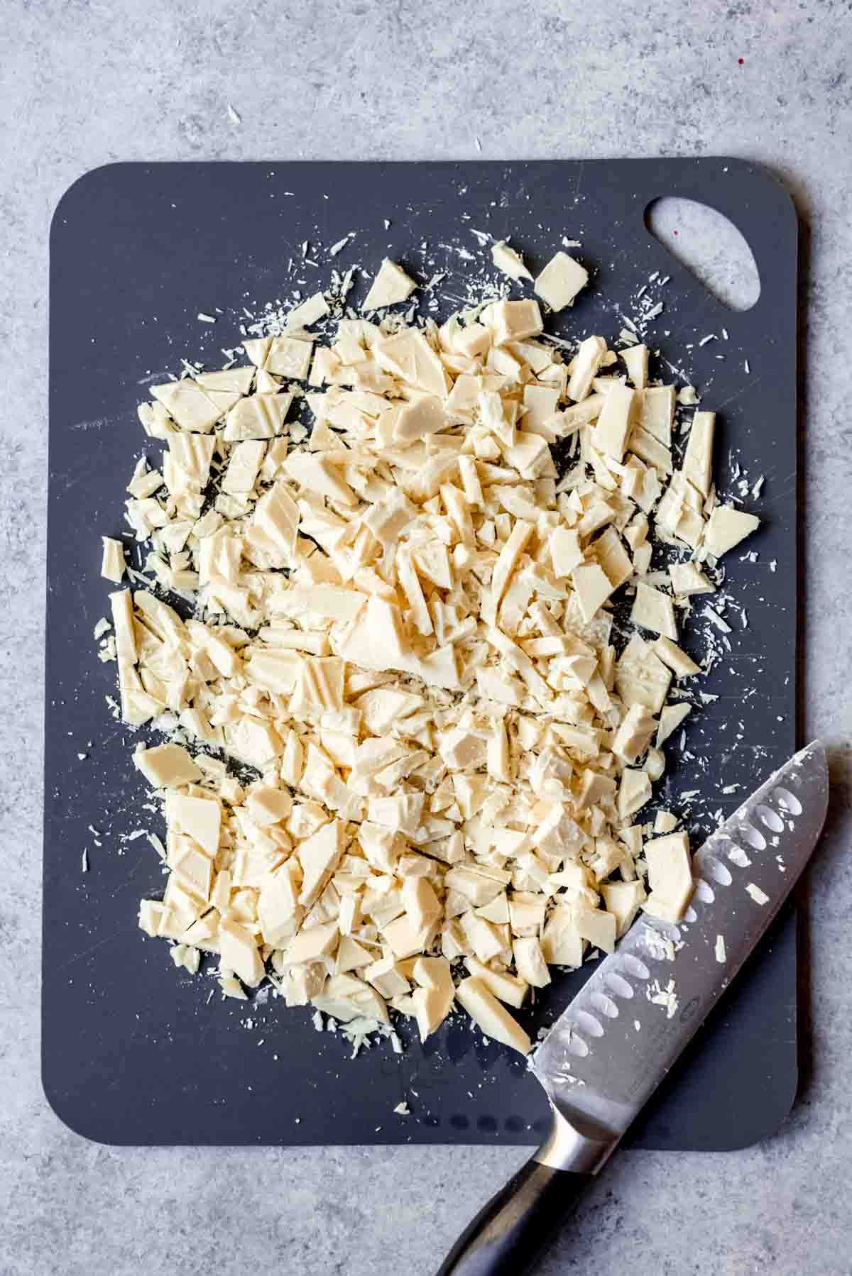 Chopped white chocolate on a cutting board.