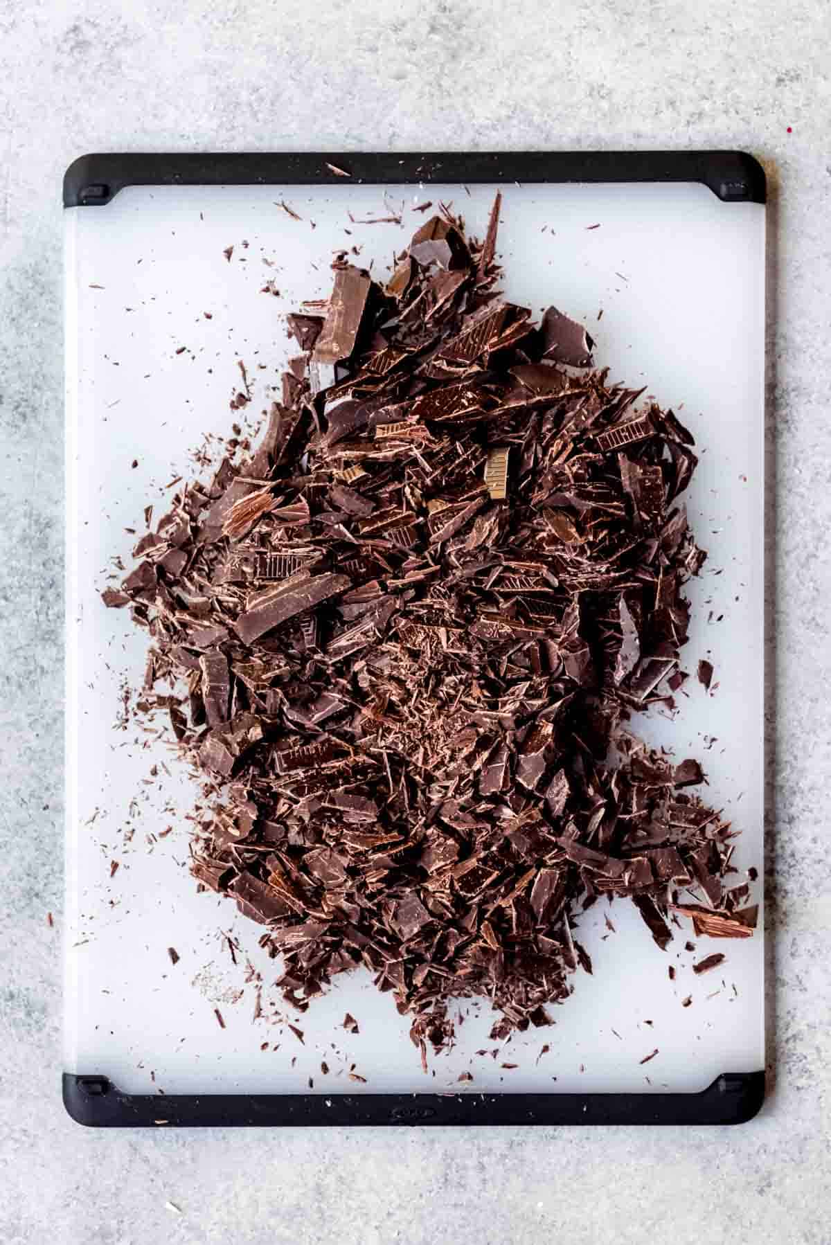 Chopped dark chocolate on a cutting board.