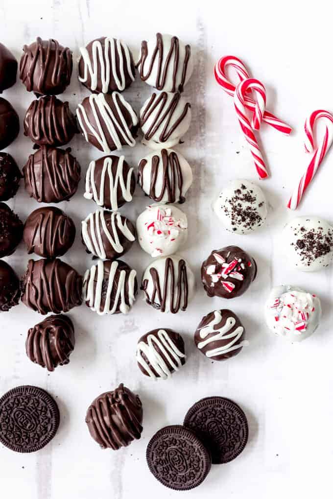 An image of Oreo balls covered in white and dark chocolate and decorated with drizzled chocolate and crushed candy canes.