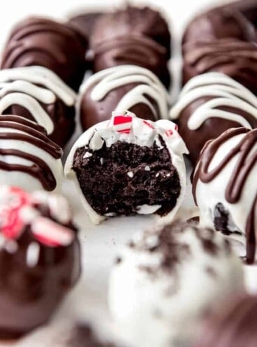 An assortment of Oreo truffle balls with one in the center missing a bite.