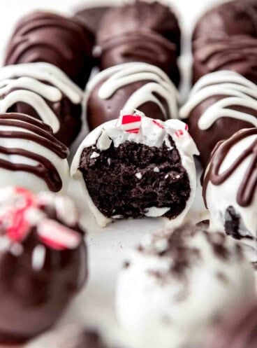 An image of a peppermint Oreo ball truffle with a bite taken out of it.