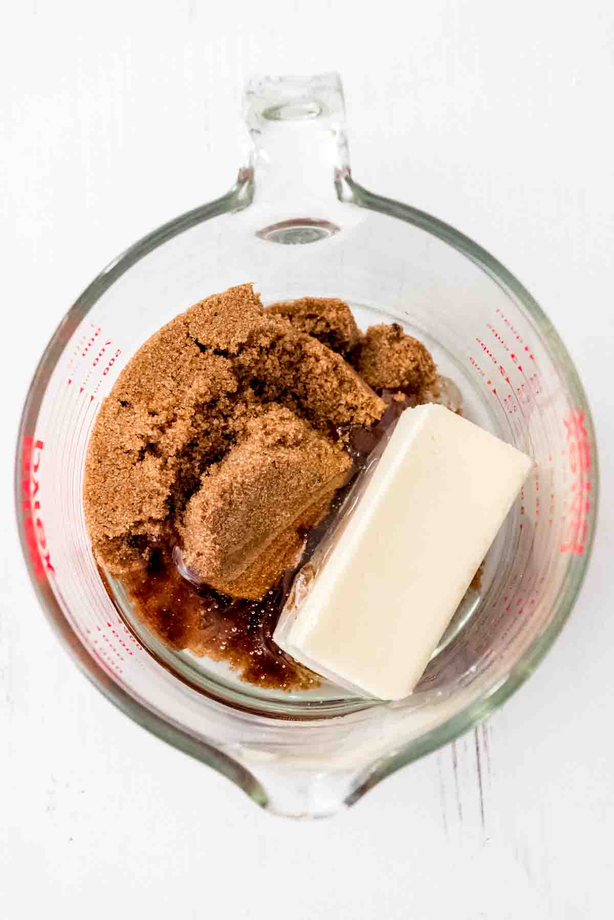 Butter, brown sugar, and corn syrup in a glass mixing bowl.