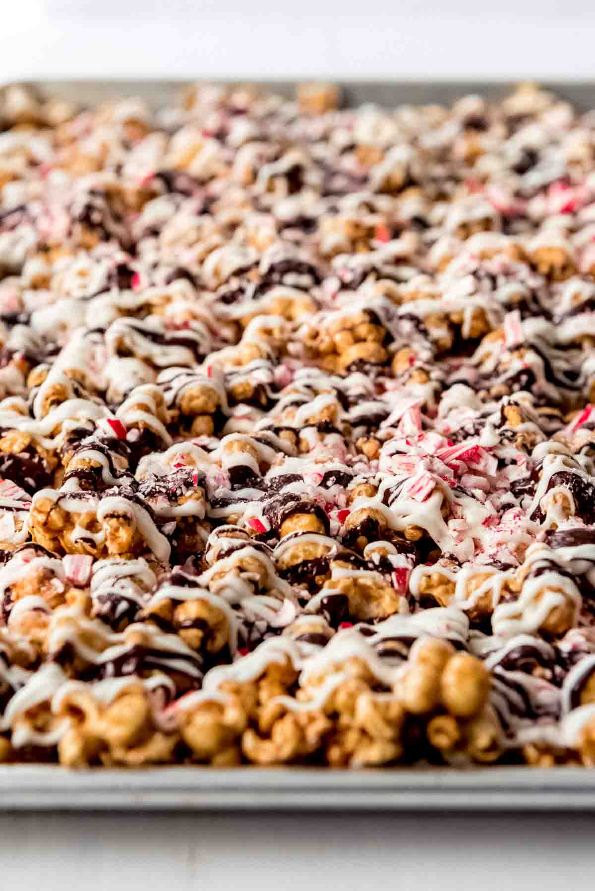 An image of peppermint bark caramel corn on a baking sheet.