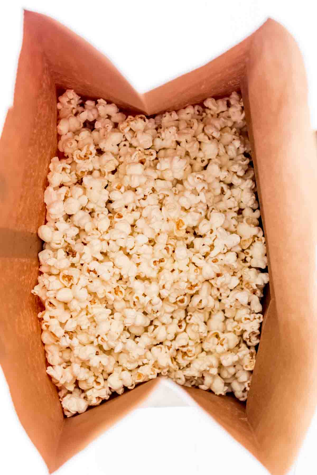 An overhead image of popcorn in a brown paper bag.