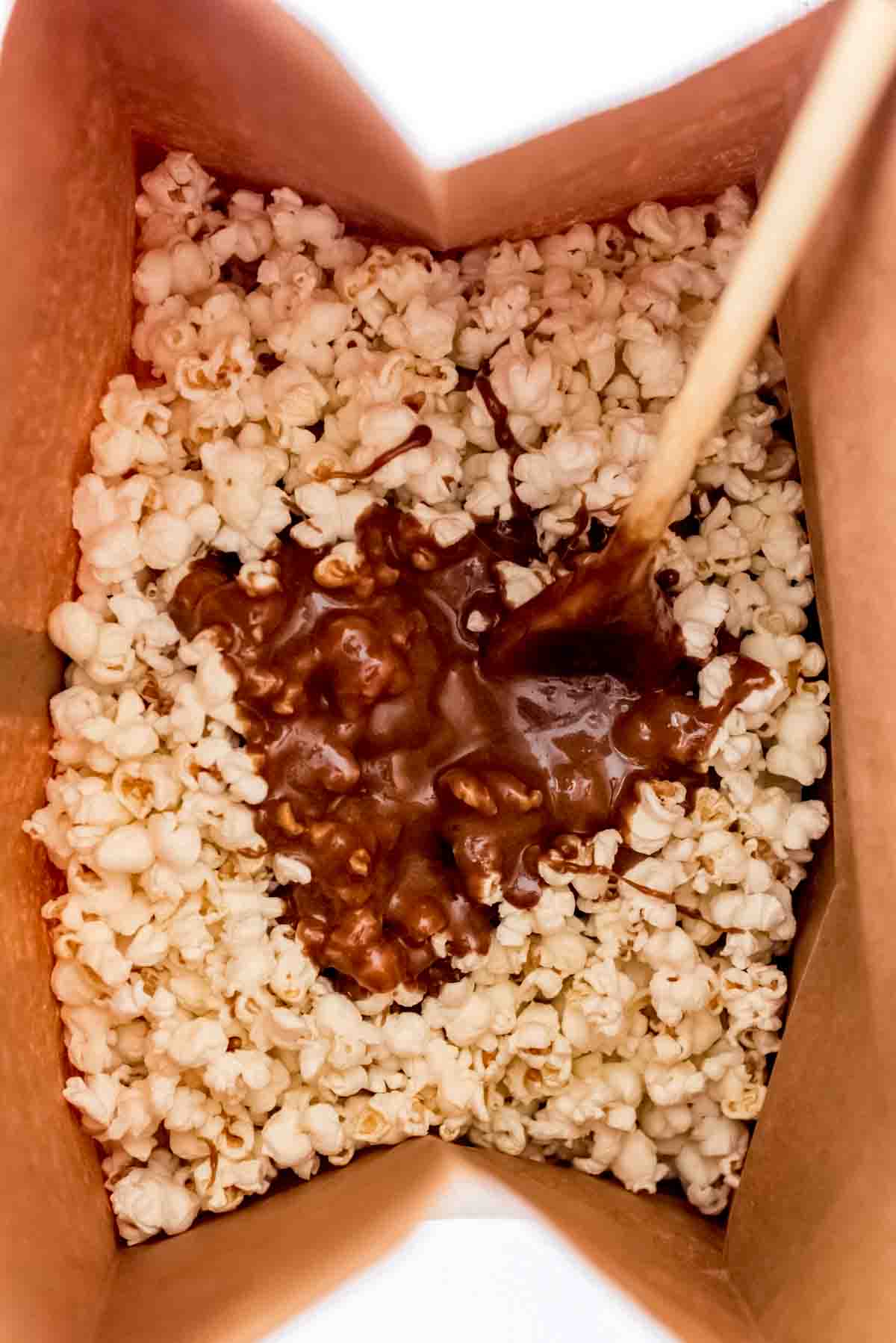 Adding caramel to a bag of popcorn.