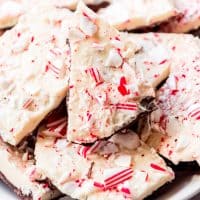 A close-up image of crushed candy canes on white and dark chocolate peppermint bark.